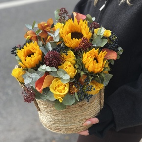 Композиция в сумке "Тональность" из подсолнухов, калл, ягод вибирнума, лимонных роз, скиммии и орхидеи в Видном